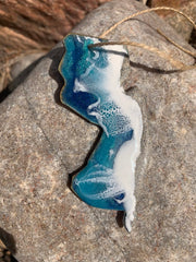 Ornament featuring ocean waves captured in resin