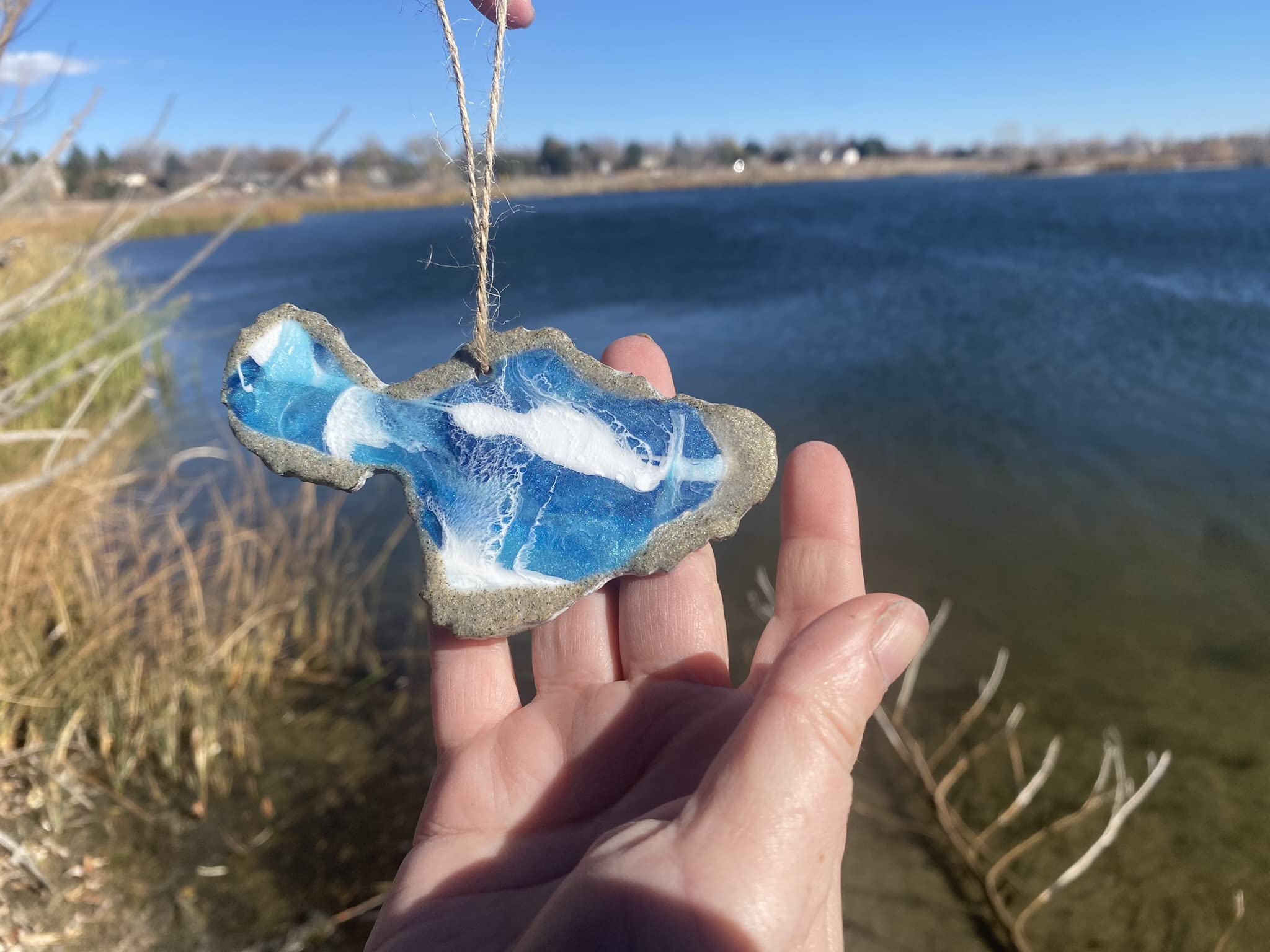 Handmade resin ornament capturing ocean waves and sand texture