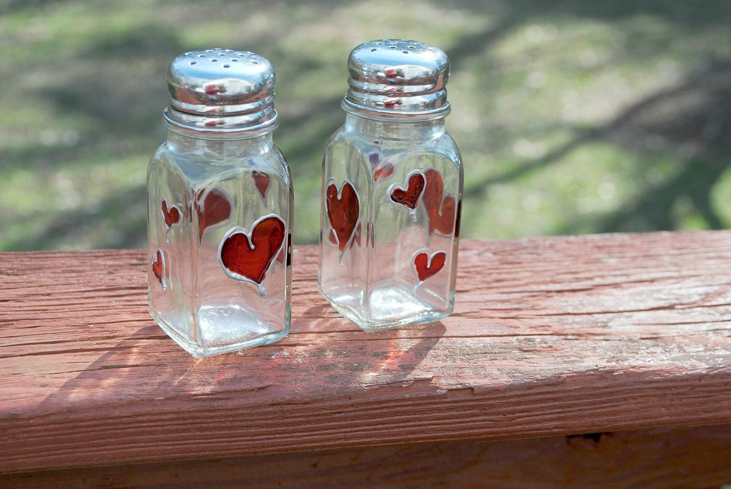 Salt and pepper shakers 4 inches tall glass with red hearts