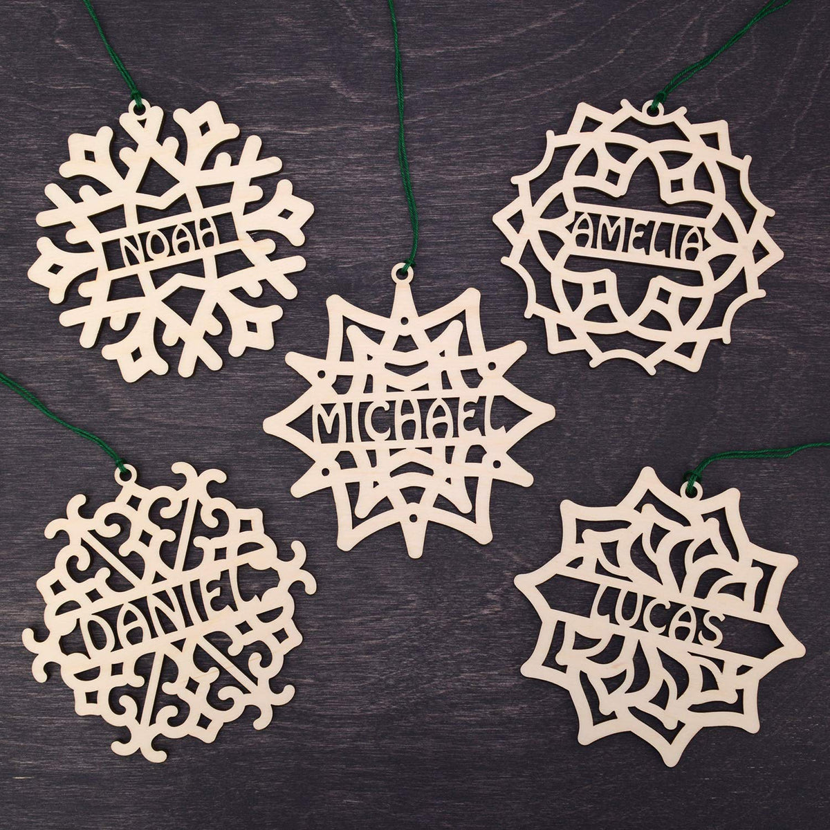 Five wooden snowflake ornaments from the Set of 5 Christmas Ornament Personalized set