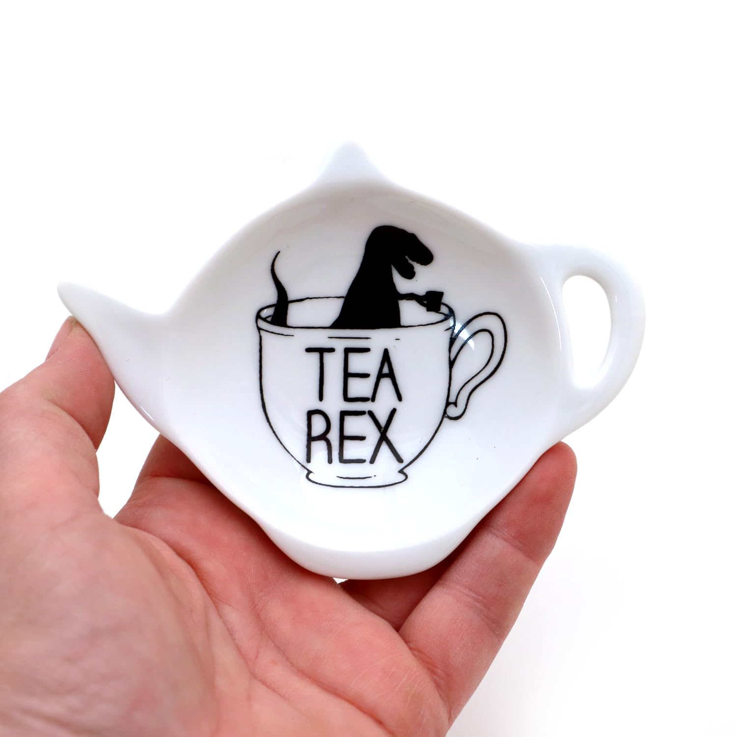 Teapot shaped teabag holder with a T Rex popping out
