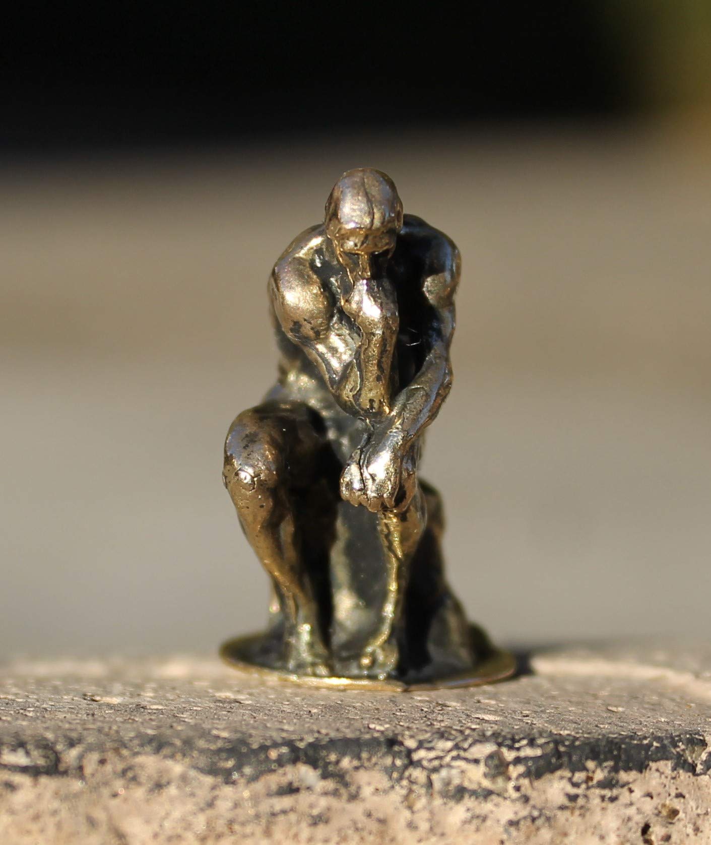 The Thinker brass figurine on bookshelf display