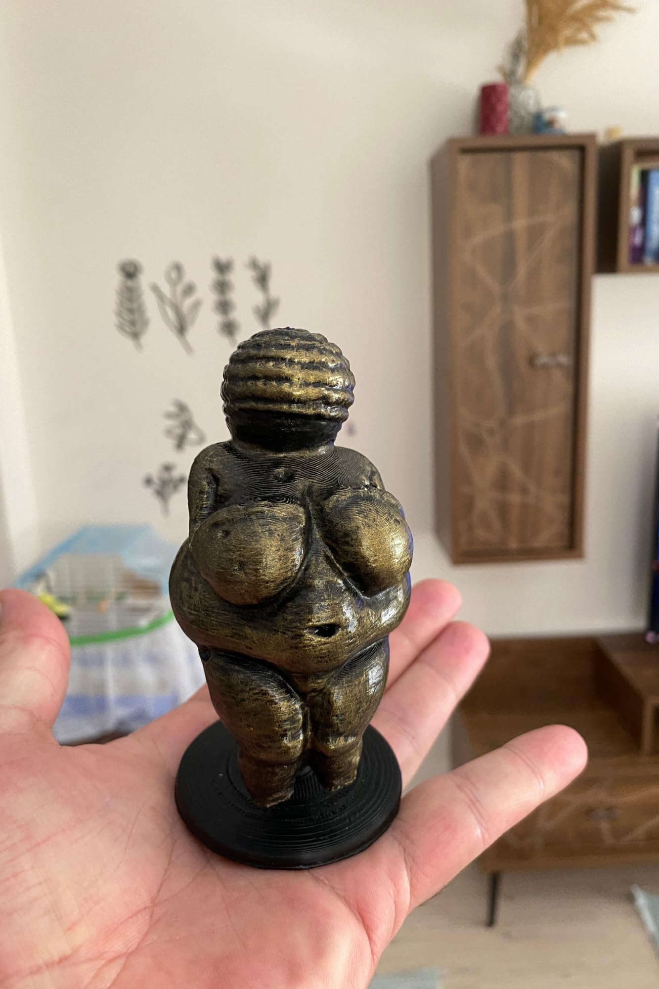 Venus of Willendorf statue displayed on stand for shelf