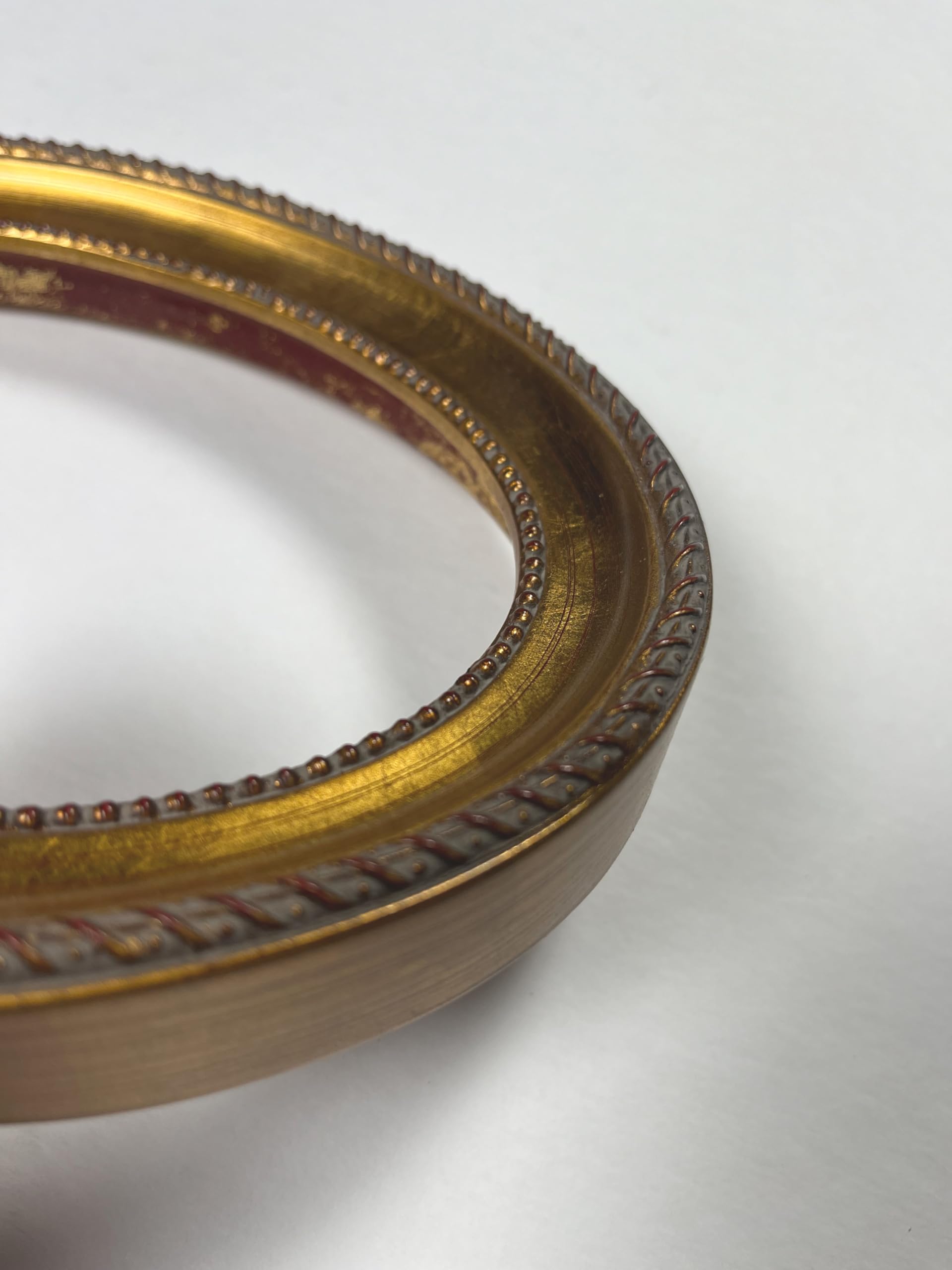 Handleafed gold ornament on oval frame