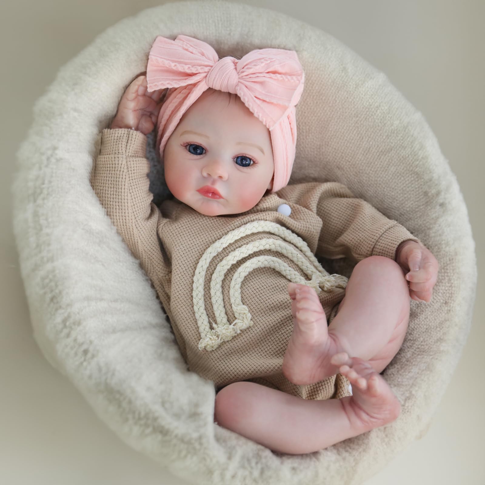 Tan knit outfit with rainbow stripes and pink bow on doll